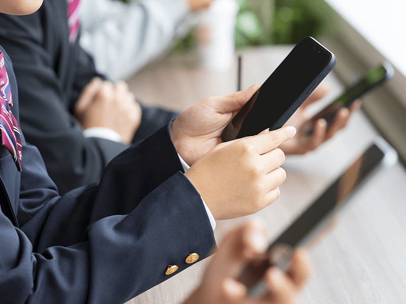 スマートフォンを見る高校生